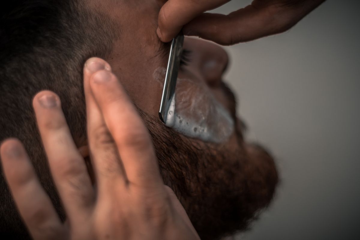 Male client receiving professional beard trimming